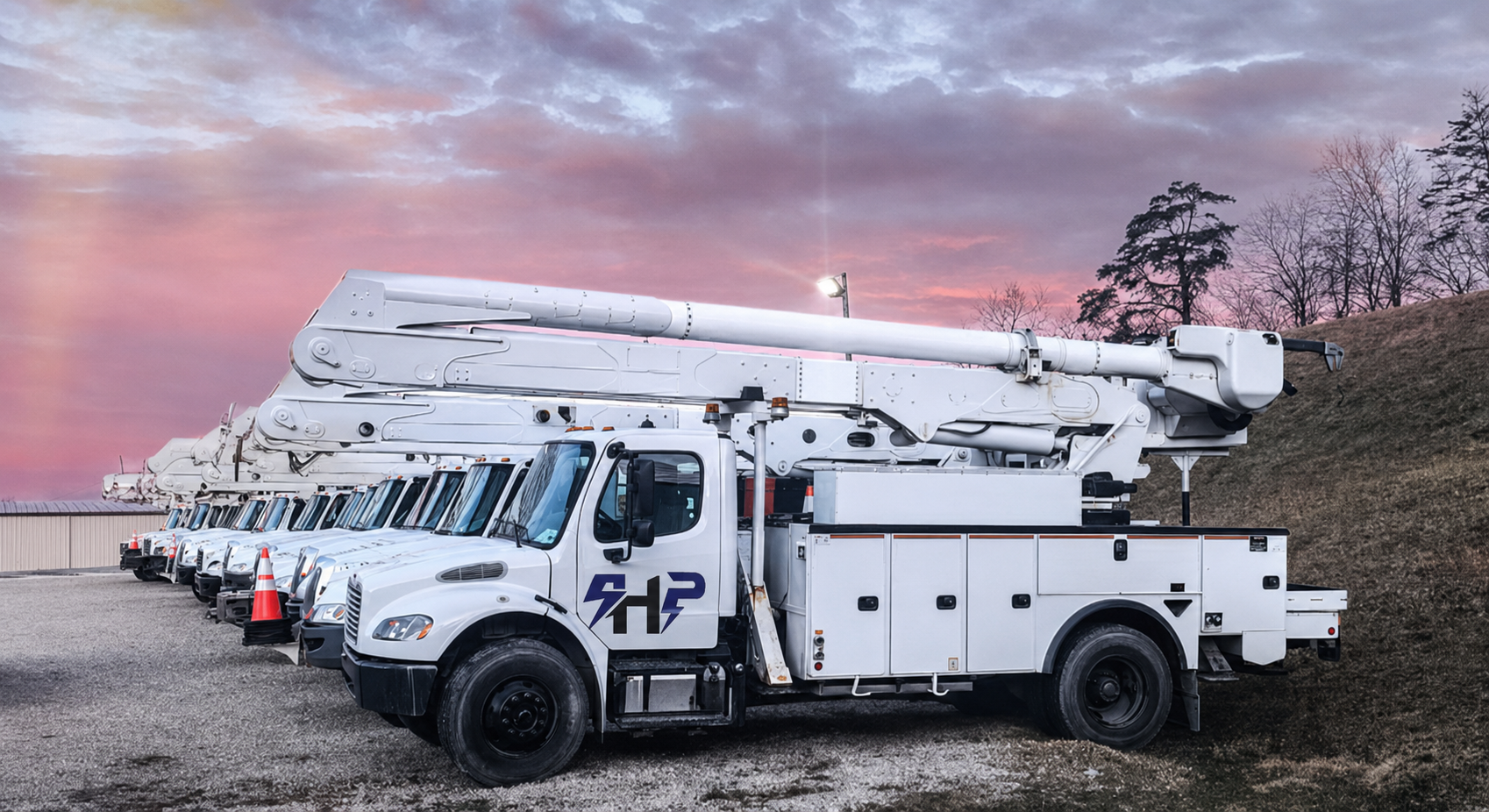 SkyHigh Power bucket trucks lined up at sunset